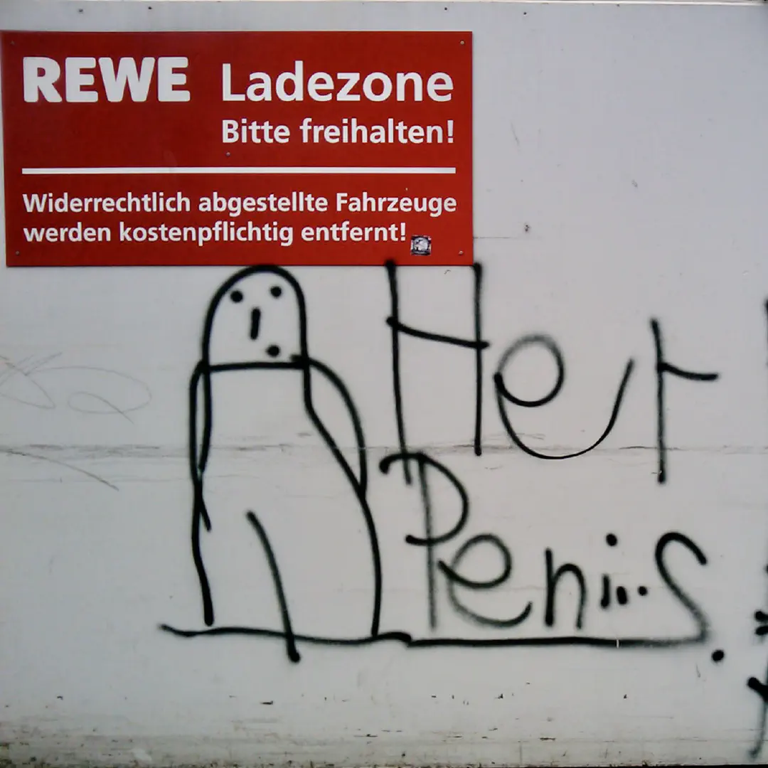 A graffiti of a stick figure resembling a penis and the text 'Herr Penis bei REWE' next to it